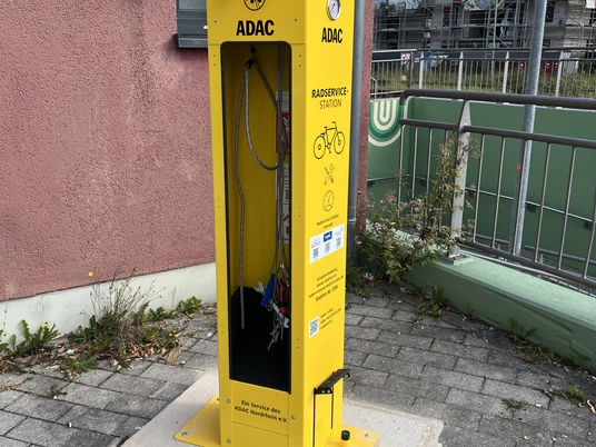 Radservice-Station Overath Gelbe Radservicestation vom ADAC mit Werkzeugen und Fahrradpumpe, nahe Bahngleisen.