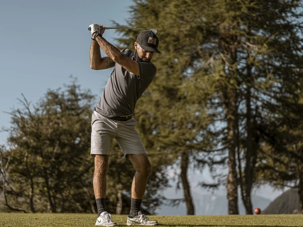 Golfeurs au départ de Riederalp Cours d'initiation au golf dans l'Aletsch Arena avec un joueur donnant un coup de départ puissant sur le terrain de golf de Riederalp dans les Alpes.