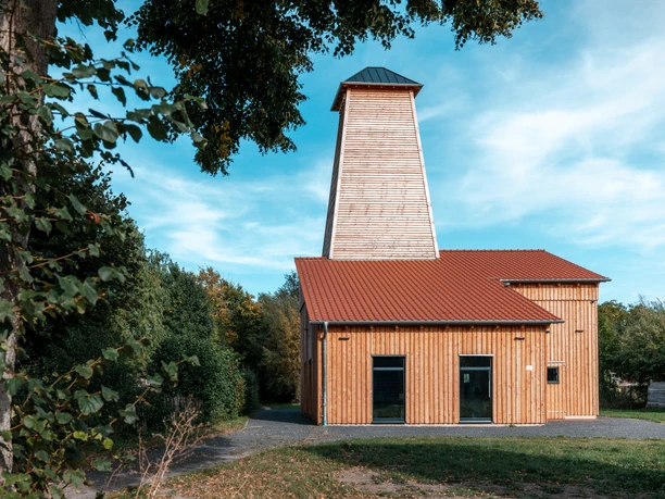 Saline Salzderhelden ©Florian Spieker Holzverkleidetes Saline in Salzderhelden mit rotem Ziegeldach unter blauem Himmel.