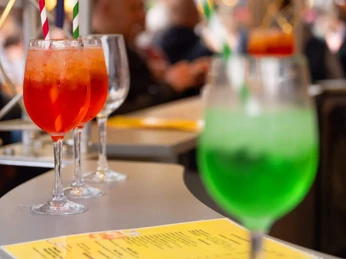 Cocktails, After-work market on Chlodwigplatz Cocktails with colorful straws stand on a counter, behind them blurry market visitors.