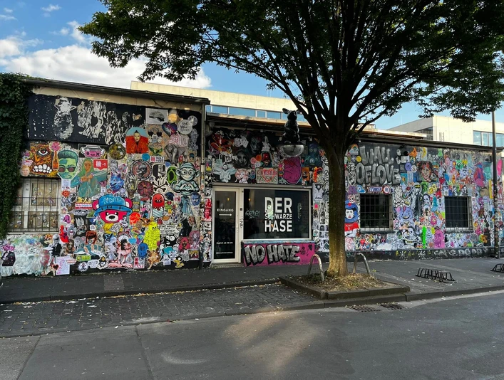 Der schwarze Hase Graffiti-bedeckte Fassade eines Gebäudes in urbaner Umgebung mit teils farbenfrohen Motiven.Graffiti-covered facade of a building in an urban environment with partly colorful motifs.
