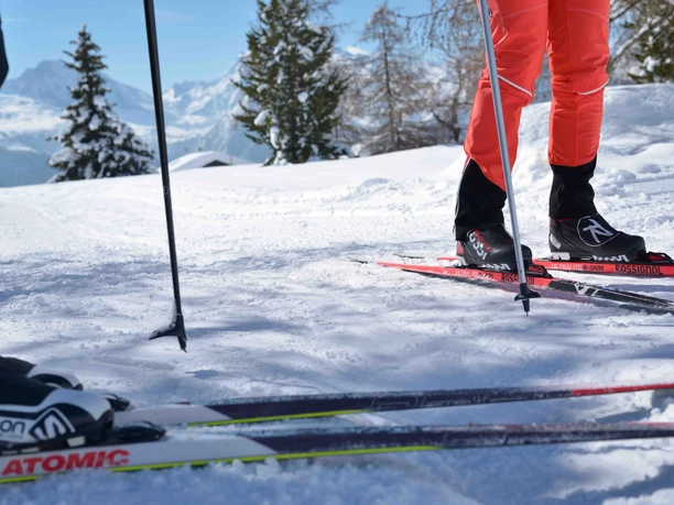 Détail de skis de fond sur une piste enneigée Cours d'initiation au ski de fond à Riederalp avec vue détaillée de skis de fond sur une piste fraîchement préparée