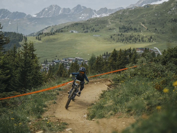 Enfant lors d'une course de VTT à Bettmeralp Kinderbikekurs Bettmeralp mit junger Teilnehmerin auf dem Flowtrail vor der Bergkulisse der Aletsch ArenaBettmeralp children's bike course with a young participant on the flow trail against the mountain backdrop of the Aletsch ArenaCours de VTT pour enfants à Bettmeralp avec une jeune participante sur le flowtrail devant le décor montagneux de l'Aletsch Arena