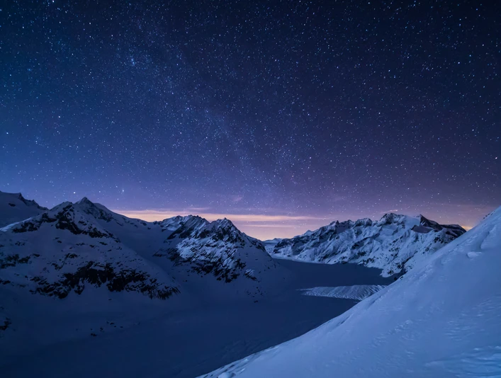 Starry sky over the Aletsch Glacier Sternenfotografie Bettmerhorn mit Blick auf den verschneiten Aletschgletscher unter funkelndem NachthimmelStar photography Bettmerhorn with a view of the snow-covered Aletsch glacier under a sparkling night skyPhotographie en étoile du Bettmerhorn avec vue sur le glacier d'Aletsch enneigé sous un ciel nocturne scintillant