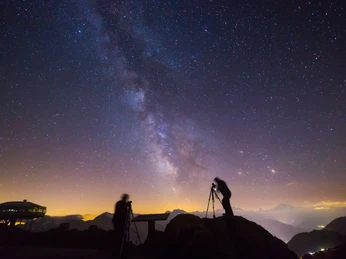 Astrophotographers under the Milky Way Sternenfotografie Bettmerhorn zeigt zwei Fotografen mit Stativen unter der leuchtenden Milchstrasse hoch über der Aletsch ArenaStar photography Bettmerhorn shows two photographers with tripods under the glowing Milky Way high above the Aletsch ArenaLa photographie d'étoiles du Bettmerhorn montre deux photographes avec des trépieds sous la voie lactée lumineuse au-dessus de l'Aletsch Arena.
