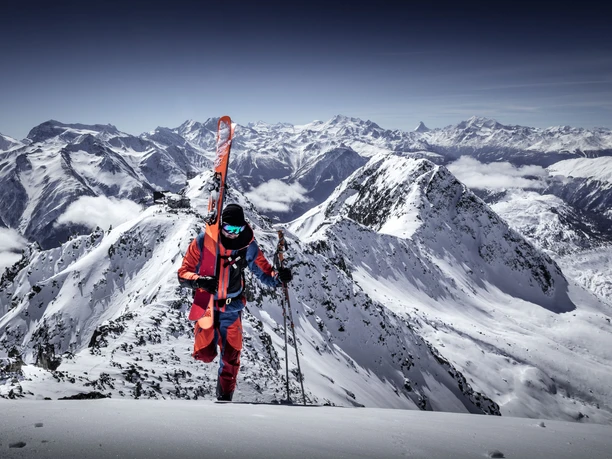 Ascent with skis on the Eggishorn Aletsch Glacier round tour Ski with climber on the Eggishorn, skis on rucksack, with a view of the Valais Alps