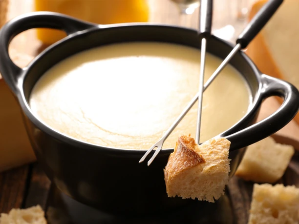 Fondue au fromage suisse classique Fondue ou raclette Aletsch Arena avec fondue au fromage suisse traditionnelle et morceaux de pain au restaurant Chüestall Riederalp