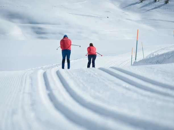 Ski de fond sur une piste fraîchement tracée Cours d'initiation au ski de fond Bettmeralp dans l'Aletsch Arena avec deux participants sur une piste fraîchement préparée en hiver