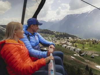 Voyage de printemps avec le télésiège Hohfluh Frühlingsfahrten Hohfluh mit Wanderern auf einem Bergweg oberhalb des Grossen AletschgletschersSpring rides Hohfluh with hikers on a mountain trail above the Great Aletsch GlacierCourses printanières Hohfluh avec des randonneurs sur un chemin de montagne au-dessus du grand glacier d'Aletsch