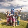 Kindergruppe mit Gletschi in den Alpen Gletschi Programm Aletsch Arena mit fröhlicher Kindergruppe und Maskottchen Gletschi beim Spielen auf der Bettmeralp im SommerGletschi Program Aletsch Arena with a cheerful group of children and mascot Gletschi playing on Bettmeralp in summerProgramme Gletschi Aletsch Arena avec un joyeux groupe d'enfants et la mascotte Gletschi jouant sur la Bettmeralp en été