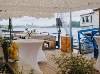 IMG_4665.JPG Hochzeitslocation mit Wasserblick, dekoriert mit Luftballons und weißen Stehtischen.Wedding location with a view of the water, decorated with balloons and white bar tables.