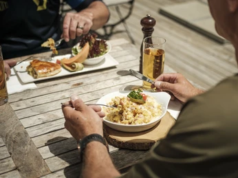 Walliser Spezialitäten für Biker Bike Genuss Tour Aletsch Arena mit Bikern beim Genuss regionaler Walliser Spezialitäten auf der Sonnenterrasse nach der TourBike pleasure tour Aletsch Arena with bikers enjoying regional Valais specialties on the sun terrace after the tourBike Genuss Tour Aletsch Arena avec des vététistes dégustant des spécialités régionales valaisannes sur la terrasse ensoleillée après le tour