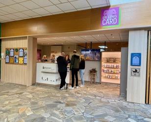 Bispingen-Touristik-Center-Parcs.jpg Empfangsbereich der Bispingen Touristik im Center Parcs mit Informationsschalter, Personal und Besuchern.