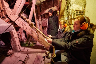 Nachtsanggelaeut Menschen sind im Kirchturm bei einer Glocke