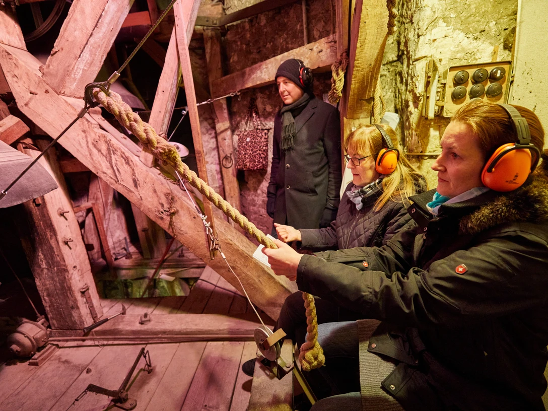 Nachtsanggelaeut Menschen sind im Kirchturm bei einer Glocke