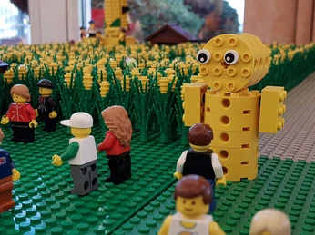 bricks-am-meer-maislabyrinth Lego-Maislabyrinth mit Figuren und gelbem Maismaskottchen in einer detailreichen Feldszene