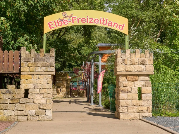 Toegangshek tot Elbe-Freizeitland met geel bord en stenen pilaren.