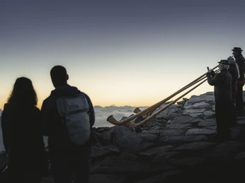 Joueurs de cor des Alpes à l'aube Sonnenaufgangsfahrt Eggishorn mit Alphornbläsern beim Spiel im Morgenlicht vor der AlpenkulisseEggishorn sunrise ride with alphorn players playing in the morning light against the Alpine backdropVoyage au lever du soleil Eggishorn avec des joueurs de cor des Alpes jouant dans la lumière du matin devant le décor alpin