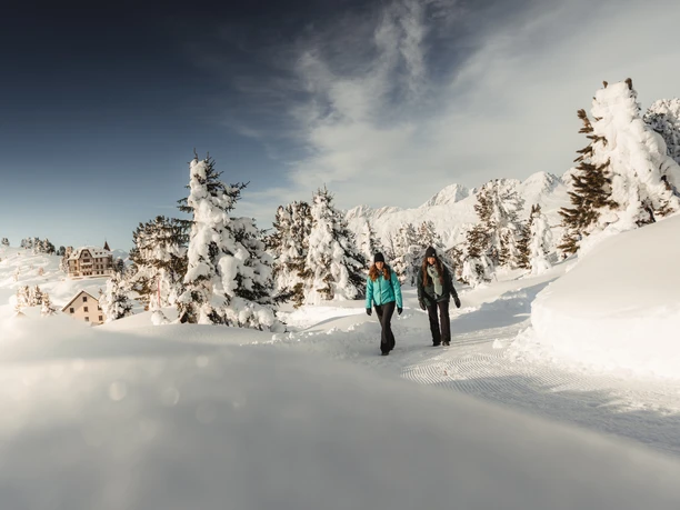 Randonnée dans la neige avec vue sur la Villa Cassel Passeport découverte d'Aletsch avec deux femmes lors d'une randonnée hivernale au-dessus de la Villa Cassel à Riederalp