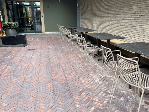 Inner courtyard (upper area).jpg Terrace with tables and chairs and flower pots