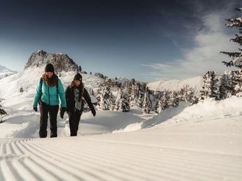 Randonnées hivernales dans l'Aletsch Arena Aletsch Entdeckerpass mit zwei Frauen beim Winterwandern auf der Riederalp in der verschneiten Aletsch ArenaAletsch Discovery Pass with two women on a winter hike on the Riederalp in the snow-covered Aletsch ArenaPasseport découverte d'Aletsch avec deux femmes lors d'une randonnée hivernale à Riederalp dans l'Aletsch Arena enneigée