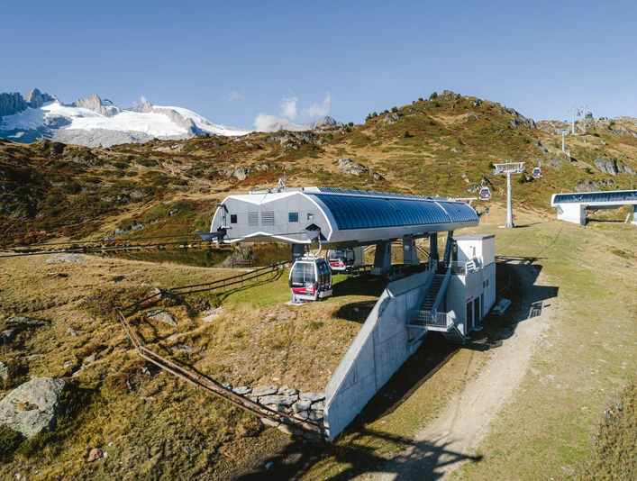 Mittelstation mit Aussicht auf den Blausee Einzelfahrten Aletsch Arena mit moderner Mittelstation und Blick auf den Blausee im SommerSingle rides Aletsch Arena with modern middle station and view of the Blausee in summerTrajets individuels Aletsch Arena avec station intermédiaire moderne et vue sur le lac Blausee en été