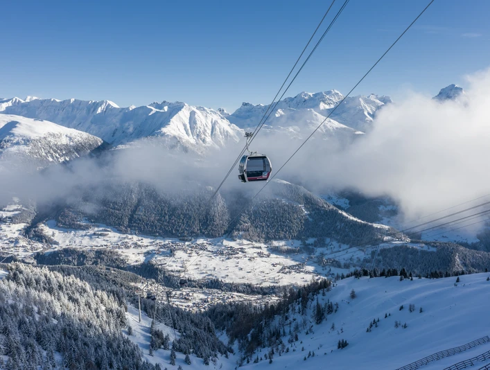 Voyage en télécabine au-dessus de Fiesch en hiver Einzelfahrten Aletsch Arena mit Gondel über verschneiten Wäldern und Blick auf das Dorf Fiesch und die Walliser AlpenSingle rides in the Aletsch Arena with gondola over snow-covered forests and views of the village of Fiesch and the Valais AlpsCourses individuelles Aletsch Arena avec la télécabine au-dessus des forêts enneigées et vue sur le village de Fiesch et les Alpes valaisannes