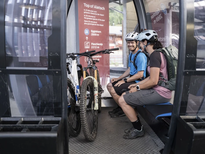 Relaxed uphill with a bike and a view Bike Transport Aletsch Arena mit Bikern in der Gondelbahn Richtung FiescheralpBike Transport Aletsch Arena with bikers in the gondola lift towards FiescheralpBike Transport Aletsch Arena avec des vététistes dans la télécabine en direction de Fiescheralp