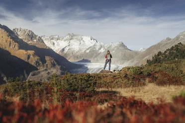 Randonnée d'automne avec vue sur le glacier d'Aletsch Soleil d'automne Aletsch Arena avec randonneuse sur le point de vue au-dessus du glacier d'Aletsch dans la lumière dorée de l'automne
