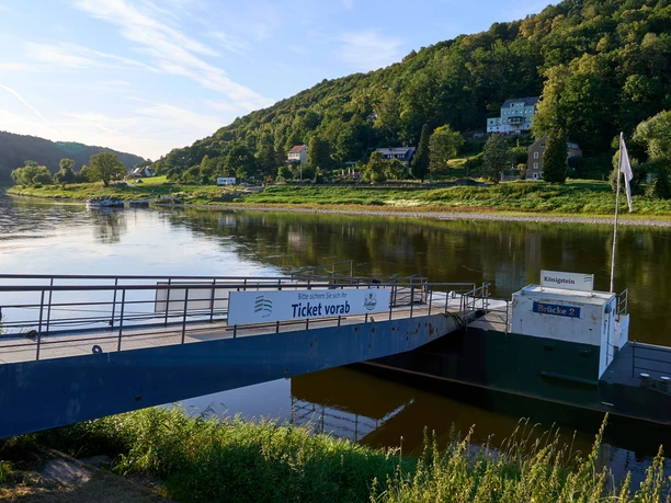 Elbe with landing stage and "Ticket sales" sign, wooded hills in the background.