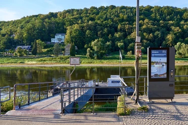Dampfschiff-Anlegestelle Königstein Anlegestelle an der Elbe mit digitalem Information- und Ticketkiosk, Bäumen im Hintergrund.