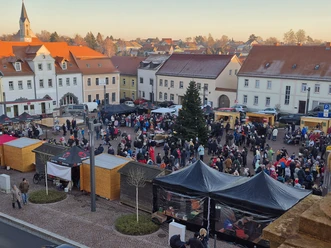 Der belebte Weihnachtsmarkt in Dahlen, umgeben von historischen Gebäuden und geschmückten Ständen.