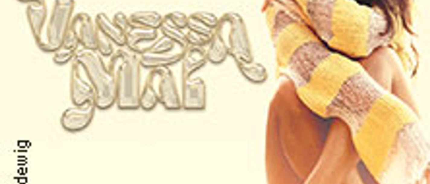 Vanessa Mai in gelbem und weißem Pullover, sitzend, bewirbt die Traumfabrik Tour 2026.