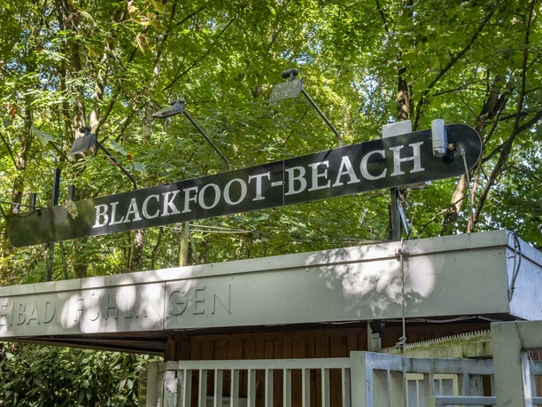 Blackfoot Beach Entrance gate to the Blackfoot Beach leisure area with green signage, surrounded by trees.