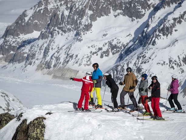 Groupe de ski avec vue sur le glacier d'Aletsch Forfait de ski pour groupes Aletsch Arena avec moniteur de ski et groupe sur le point de vue au-dessus du glacier d'Aletsch