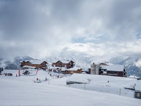 École de ski à Fiescheralp en hiver Ski Schnupperkurs Fiescheralp mit Blick auf Skischulgelände und Chalets im verschneiten BergdorfFiescheralp ski taster course with a view of the ski school grounds and chalets in the snow-covered mountain villageCours d'initiation au ski Fiescheralp avec vue sur le terrain de l'école de ski et les chalets du village de montagne enneigé