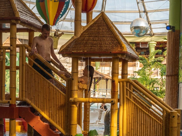 AQUALAND - wellness and aquapark Bamboo construction with water features and brightly colored slides in the leisure pool.
