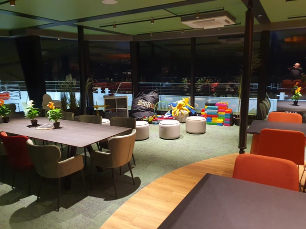 EMS Hennesee Spielecke Ein freundlicher Raum mit modernen Sitzmöbeln und bunter Kinderspielecke.