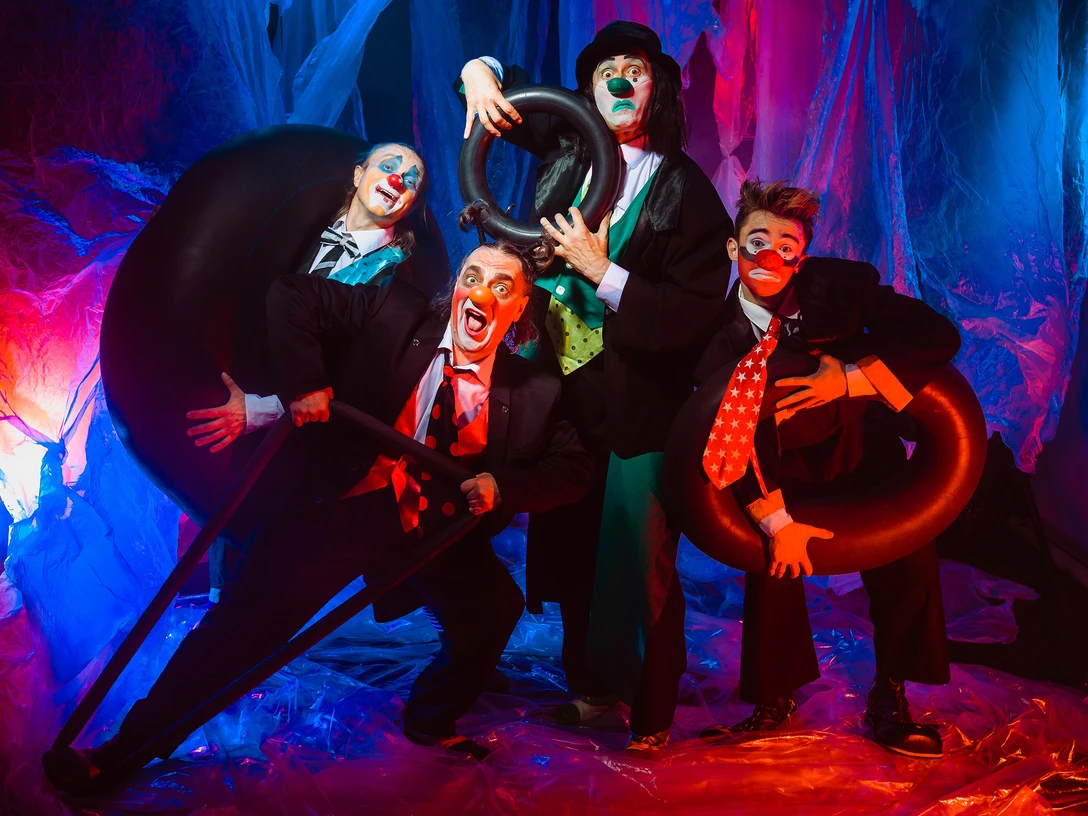 Plastic Fantastic.jpg Das Bild zeigt vier kostümierte Clowns, die Grimassen schneiden