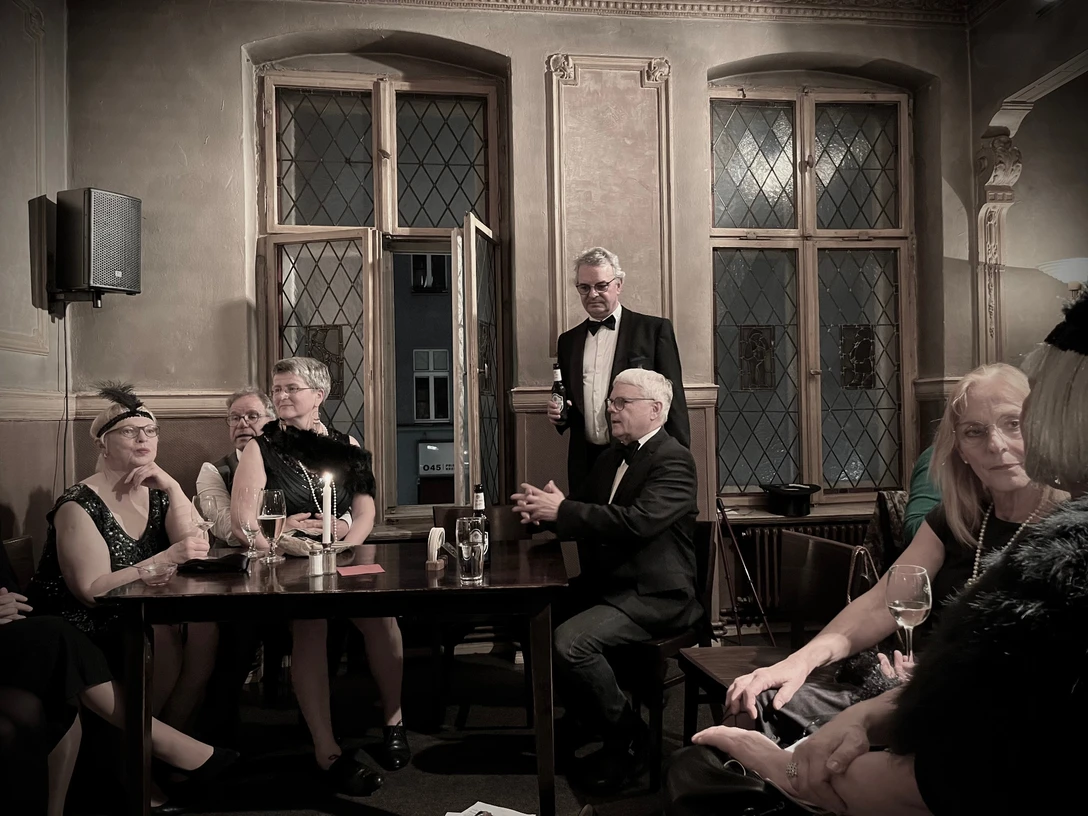 Die Voice-Pearls Berlin Bild einer Personengruppe in einer Bar im Stil der 20er JahrePicture of a group of people in a bar in the style of the 1920sFoto van een groep mensen in een bar in de stijl van de jaren 1920