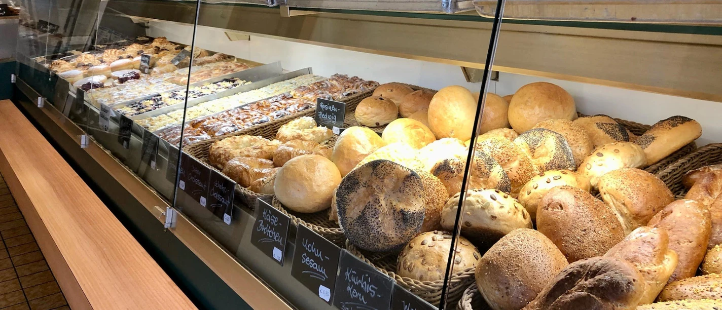 baeckerei-konditorei-bergmann-bispingen.jpg Verkaufstheke Bergmann in Bispingen mit frischen Broten, Brötchen und Kuchen in einer traditionellen Bäckerei.