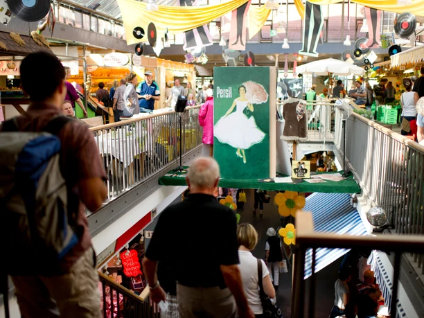 Market tables in the market hall in Kassel Lots of people are out and about in the Kassel market hall.