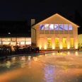Außenansicht der Roetgen Therme bei Nacht mit beleuchteten Gebäuden und einem Poolbereich.