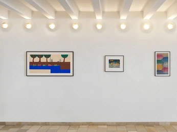 Jonas Lipps, installation view Kunstwerke an einer weißen Wand, darunter leuchten sieben Deckenspots.Works of art on a white wall, with seven ceiling spotlights below.