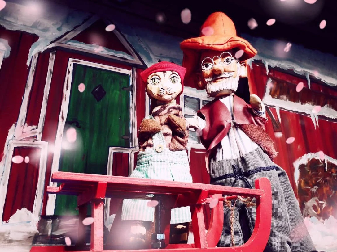 Pettersson kriegt Weihnachtsbesuch (c) Barberella.jpg Zwei Puppen, Petersson und Findus, stehen vor einer rot-weißen Hütte im Schnee.