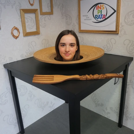 In an optical illusion at INSPIRATA, the head of a young woman appears to be lying on a plate on a table