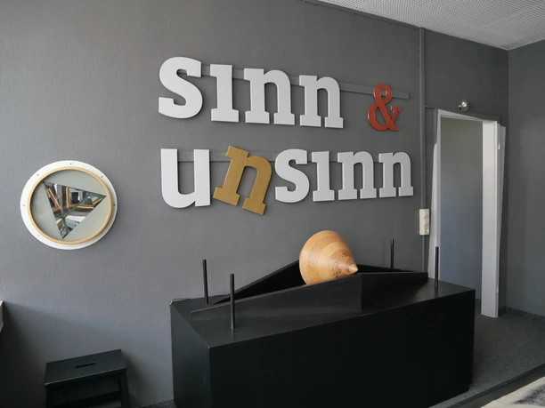 Die INSPIRATA - Zentrum für mathematisch-naturwissenschaftliche Bildung Der Schriftzug "Sinn & Unsinn" ziert die Wand eines Ausstellungsraums in der INSPIRATA Leipzig