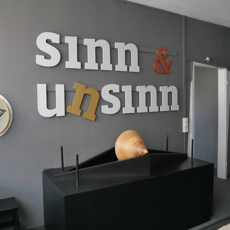 The lettering "Sense & Nonsense" adorns the wall of an exhibition room at INSPIRATA Leipzig