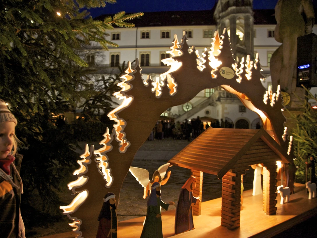Dornröschens Schlossweihnacht Torgau - Weihnachten in der Region Leipzig Ein kleiner Junge steht gebannt vor einer leuchtenden Weihnachtskrippe im Schloss.