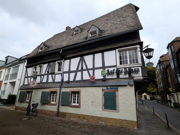 ©Bastian Ulrich - Haus auf der Arken 3 Das Bild zeigt ein traditionelles Fachwerkhaus mit neun Fenstern und einem langen Schornstein.